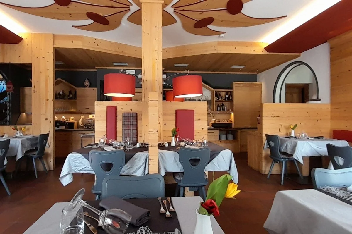 Sala ristorante ripresa dal lato opposto rispetto a dining.webp, con tavoli apparecchiati e soffitto decorato